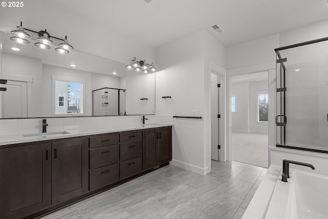 bathroom with vanity, an enclosed shower, backsplash, and a healthy amount of sunlight