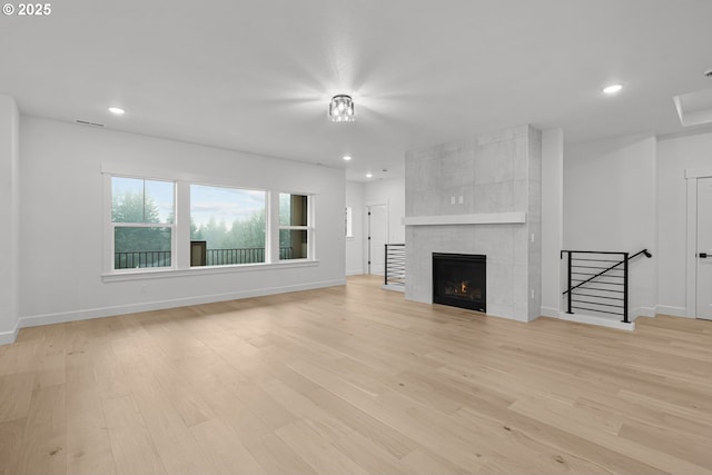 unfurnished living room featuring a fireplace and light hardwood / wood-style floors