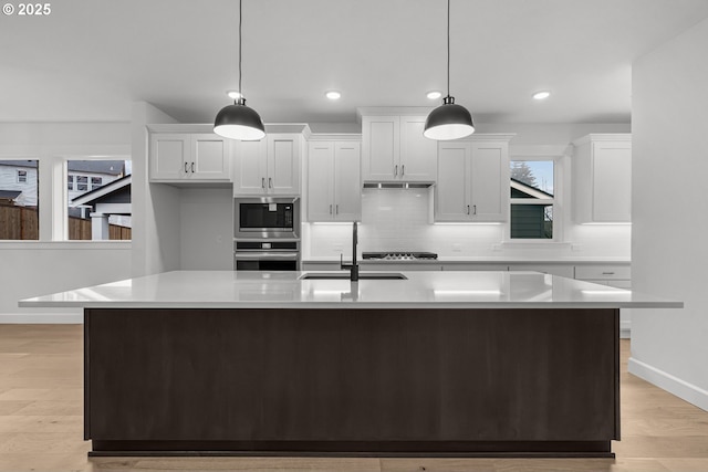 kitchen with sink, decorative light fixtures, white cabinets, and appliances with stainless steel finishes