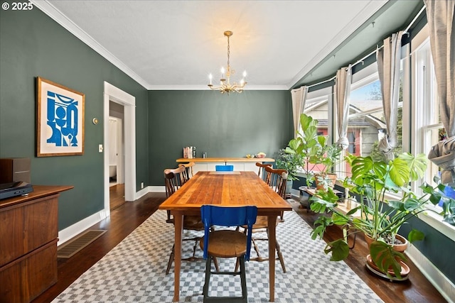 dining area with crown molding, dark hardwood / wood-style floors, and a chandelier