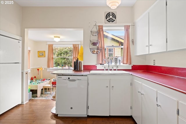 kitchen featuring dark hardwood / wood-style flooring, sink, white appliances, and white cabinets