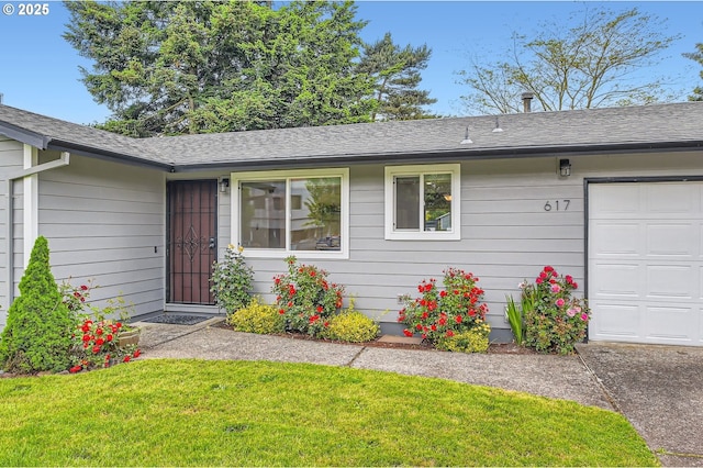 617 NW Fariss Rd, Gresham, OR 97030 - property entrance featuring an attached garage, a shingled roof, and a yard