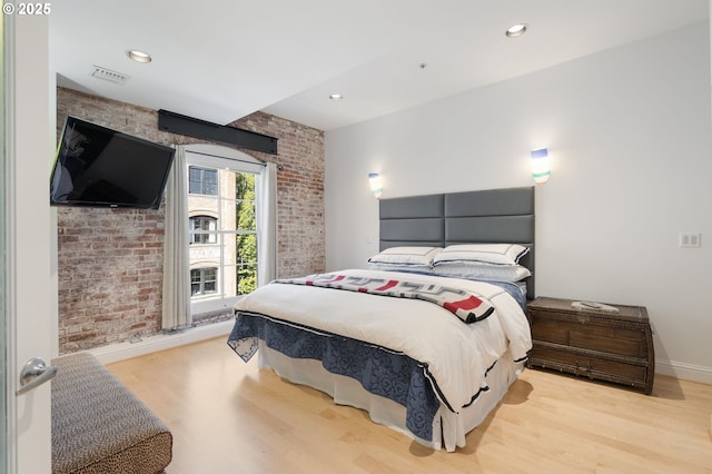 1240 NW Hoyt St Unit 6, Portland, OR 97209 - bedroom with baseboards, wood finished floors, visible vents, and brick wall