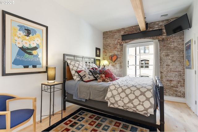 1240 NW Hoyt St Unit 6, Portland, OR 97209 - bedroom with baseboards, wood finished floors, brick wall, and visible vents