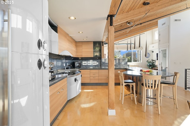 1240 NW Hoyt St Unit 6, Portland, OR 97209 - kitchen with dark countertops, modern cabinets, light wood finished floors, and tasteful backsplash