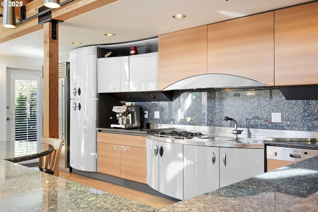 1240 NW Hoyt St Unit 6, Portland, OR 97209 - kitchen featuring a sink, decorative backsplash, dark stone counters, and stainless steel gas stovetop