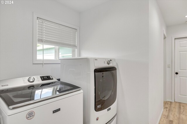 clothes washing area featuring washer and dryer and light wood-type flooring