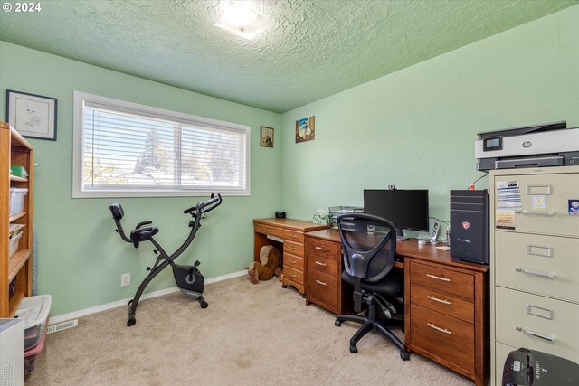 carpeted home office featuring a textured ceiling