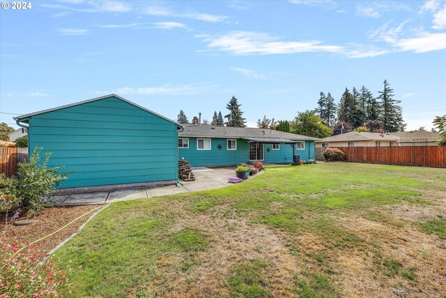 back of house with a lawn and a patio