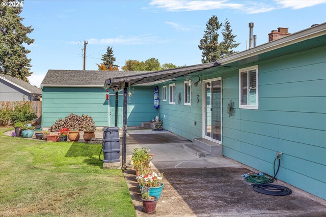 back of house with a yard and a patio