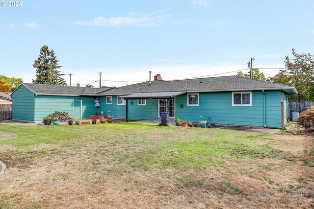 back of house with a lawn and a patio