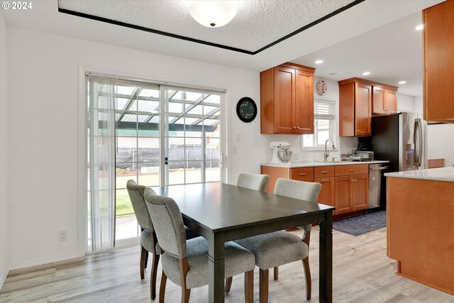 dining room featuring a textured ceiling and light wood-type flooring