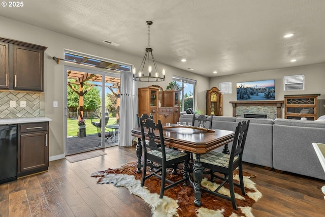 802 NW Green Forest Cir, Redmond, OR 97756 - dining room with recessed lighting, dark wood-type flooring, a fireplace, and a chandelier