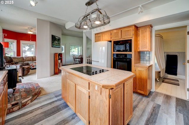 589 NW 3rd Ave, Canby, OR 97013 - kitchen with black appliances, tile counters, open floor plan, rail lighting, and a center island