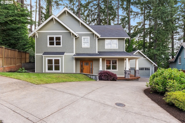 view of front facade with a front yard, covered porch, and a garage