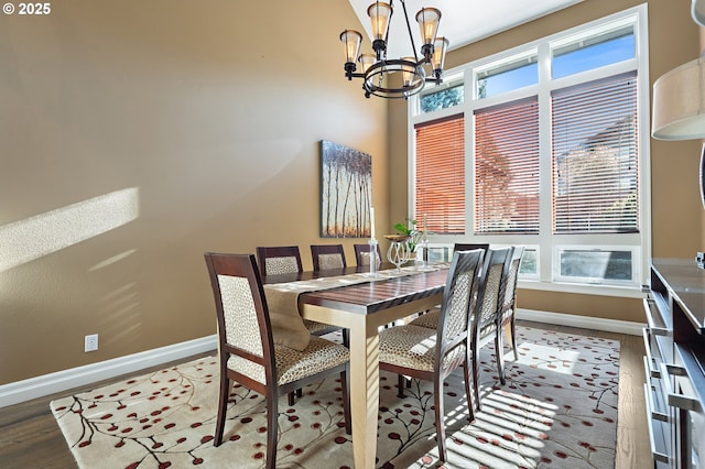 dining area with hardwood / wood-style flooring, plenty of natural light, and a notable chandelier