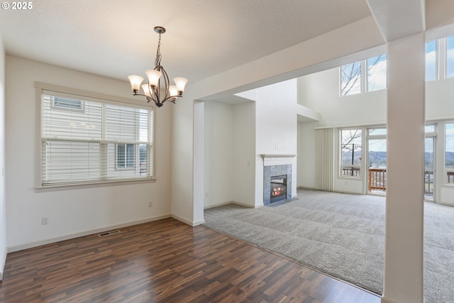 1455 NE Cooper Ln, Estacada, OR 97023 - unfurnished living room featuring baseboards, a chandelier, visible vents, a tiled fireplace, and wood finished floors