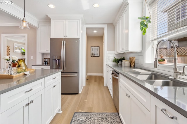 4926 NE 12th Ave, Portland, OR 97211 - kitchen featuring appliances with stainless steel finishes, a sink, white cabinets, backsplash, and recessed lighting