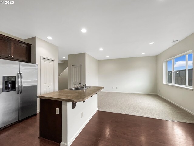 10095 NW Curtis St, North Plains, OR 97133 - kitchen featuring stainless steel refrigerator with ice dispenser, a sink, dark brown cabinetry, an island with sink, and baseboards