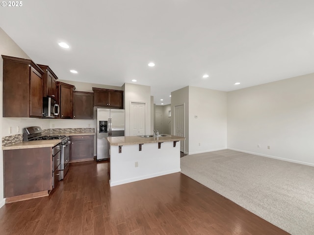 10095 NW Curtis St, North Plains, OR 97133 - kitchen with stainless steel appliances, a sink, dark brown cabinets, light countertops, and recessed lighting