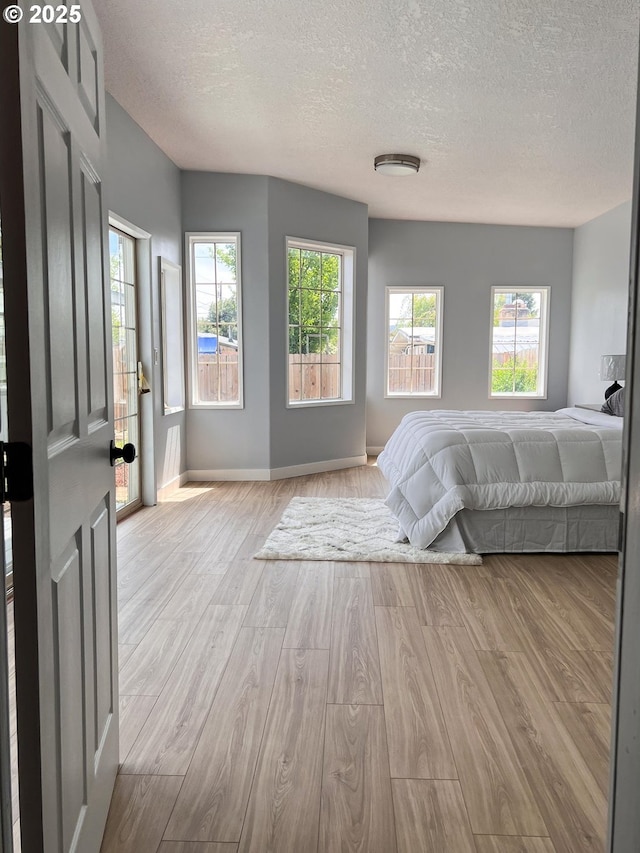 1214 NE Loper Ave, Prineville, OR 97754 - bedroom featuring a textured ceiling, wood finished floors, and baseboards