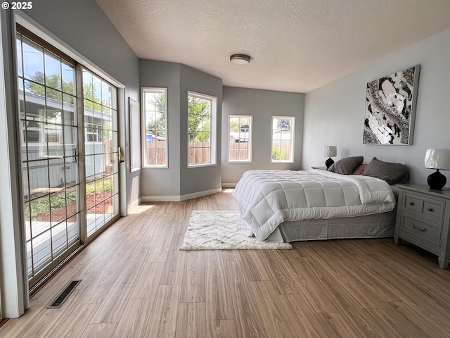 1214 NE Loper Ave, Prineville, OR 97754 - bedroom featuring a textured ceiling, light wood-type flooring, access to exterior, and baseboards
