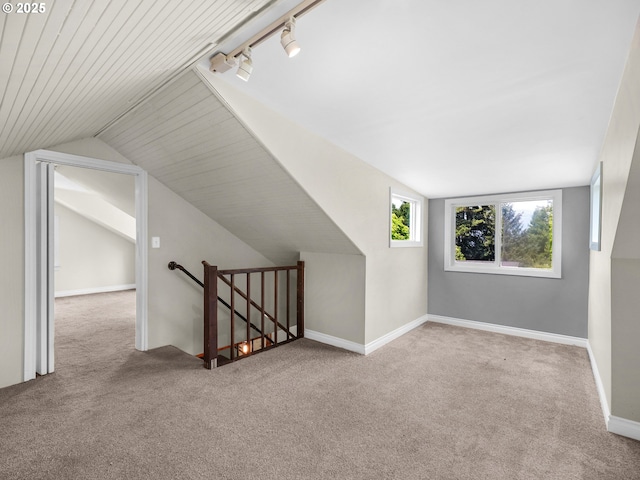 bonus room with vaulted ceiling, baseboards, and carpet flooring