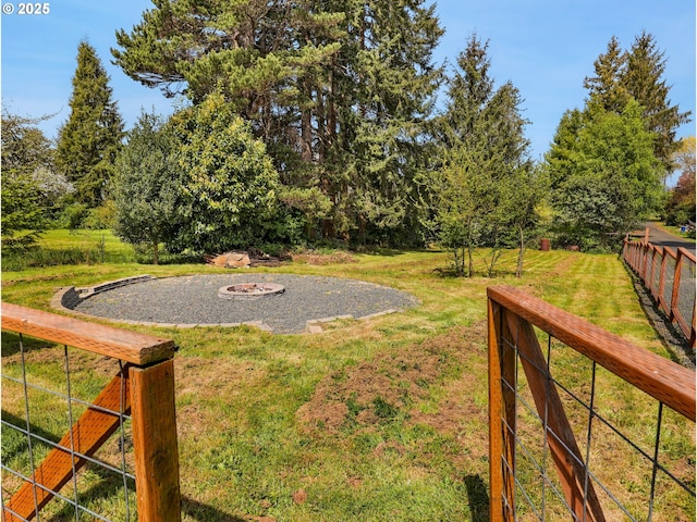 view of yard featuring a fire pit and fence