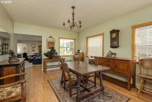 22885 S Tendril Ln, West Linn, OR 97068 - dining room with a chandelier, light wood-style flooring, and a textured ceiling