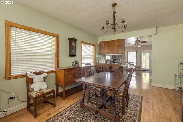 22885 S Tendril Ln, West Linn, OR 97068 - dining room featuring a chandelier, light wood-type flooring, a textured ceiling, baseboards, and a ceiling fan
