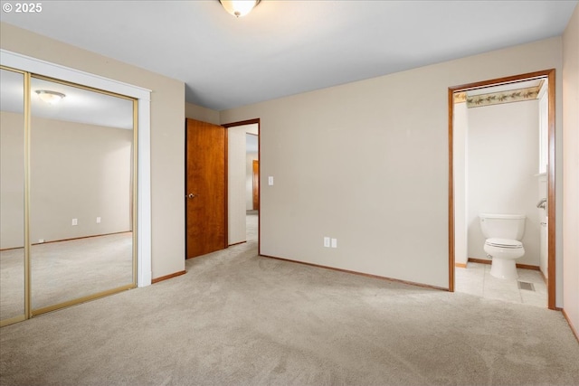 unfurnished bedroom featuring carpet, ensuite bath, and baseboards