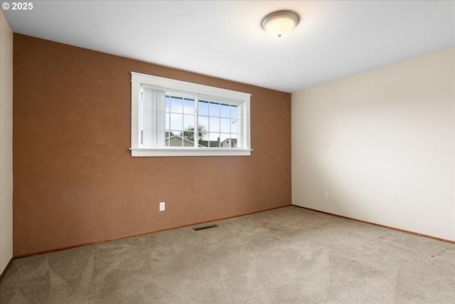 unfurnished room with carpet floors, baseboards, and visible vents