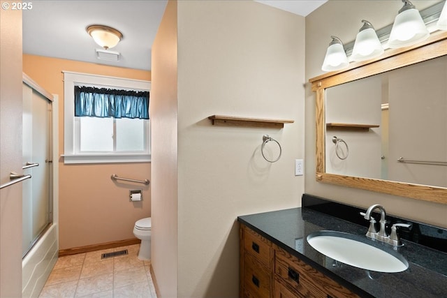 bathroom with toilet, vanity, baseboards, visible vents, and tile patterned floors