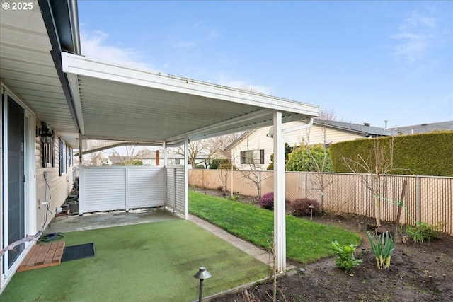 view of yard with a carport and a fenced backyard