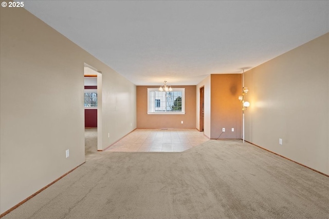 carpeted empty room featuring a chandelier