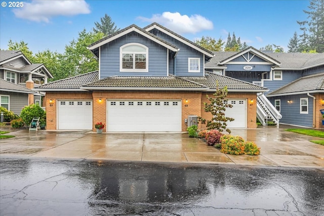 view of front of property with concrete driveway, a tiled roof, and brick siding