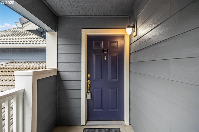 view of exterior entry with a tiled roof