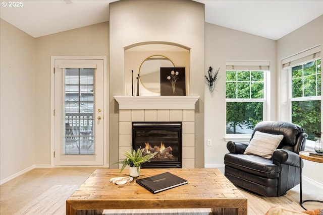 carpeted living room with a fireplace, baseboards, and vaulted ceiling