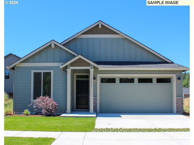 craftsman inspired home with a garage and a front yard