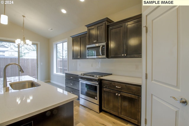 kitchen featuring appliances with stainless steel finishes, sink, decorative backsplash, hanging light fixtures, and dark brown cabinetry