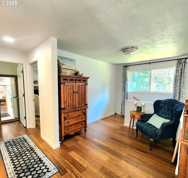 97640 Kadora Ln, North Bend, OR 97459 - sitting room featuring hardwood / wood-style flooring, baseboards, and a textured ceiling