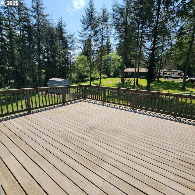 97640 Kadora Ln, North Bend, OR 97459 - wooden deck featuring a storage unit, an outbuilding, a yard, and view of wooded area