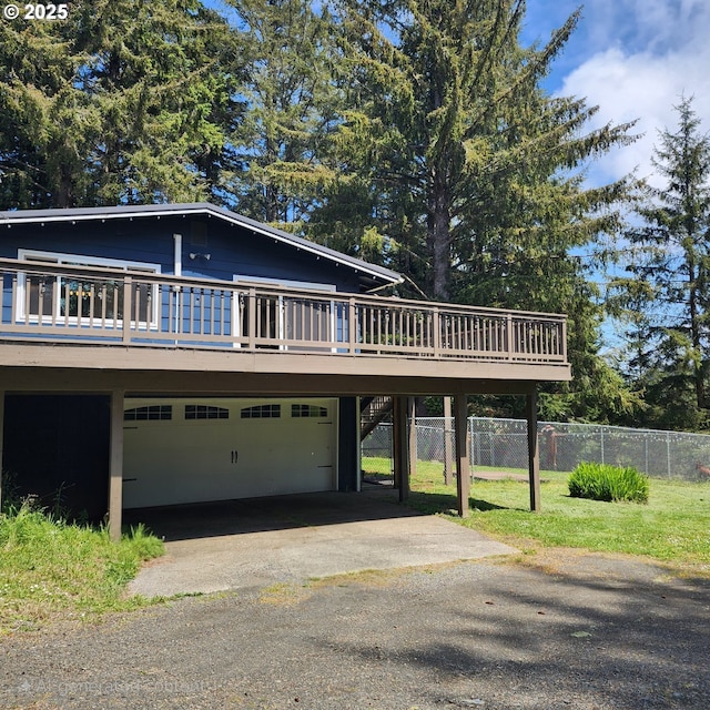 97640 Kadora Ln, North Bend, OR 97459 - view of front of house featuring a deck, asphalt driveway, an attached garage, stairway, and a carport