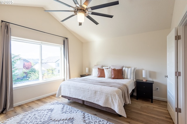bedroom with ceiling fan, baseboards, vaulted ceiling, and wood finished floors