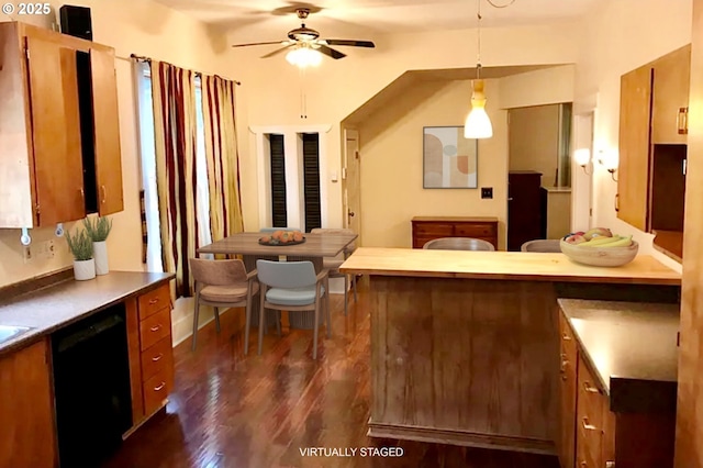 kitchen with dishwasher, dark wood-type flooring, brown cabinetry, and ceiling fan