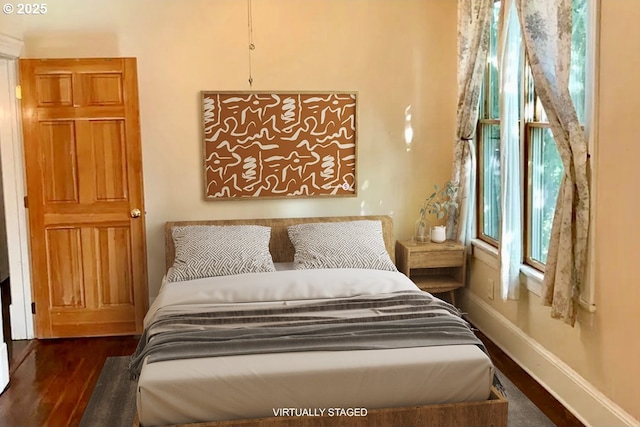 bedroom featuring baseboards and dark wood-type flooring