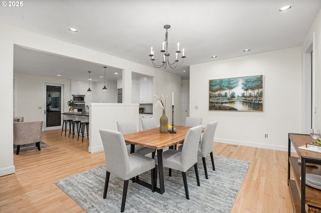 dining room featuring a notable chandelier and light hardwood / wood-style flooring