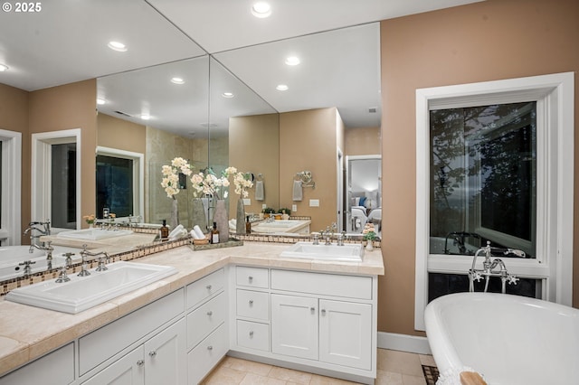 bathroom featuring tile patterned floors, vanity, and a bath