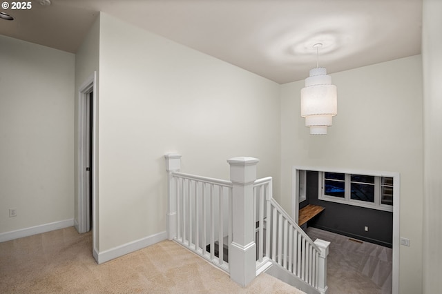 stairway featuring baseboards and carpet floors