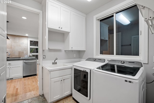 clothes washing area with washer and dryer, cabinet space, recessed lighting, and a sink